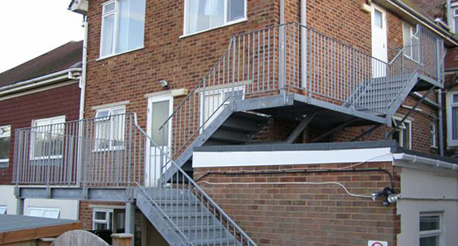 silver metal iron stairs leading to side of house